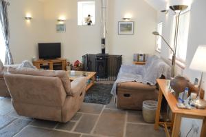 a living room with two couches and a tv at Stone Cottage in Shrewsbury