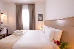 um quarto de hotel com uma cama branca com toalhas em El Misti Hotel Buenos Aires Centro em Buenos Aires