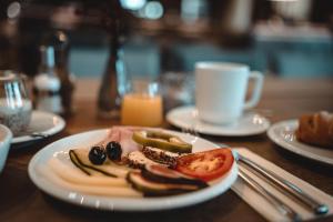 a plate of food on a table with a cup of coffee at Hotel Das Zeit in Lenzing