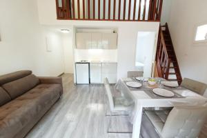 ein Wohnzimmer mit einem weißen Tisch und einem Sofa in der Unterkunft Spacious sea view apart at 50m from the beach in Bandol