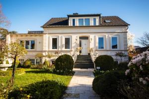 ein großes weißes Haus mit einer Treppe im Hof in der Unterkunft Villa Rosengarten auf der Sonneninsel Fehmarn in Fehmarn