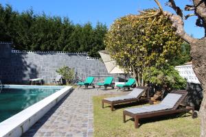 un cortile con piscina, sedie e un albero di finca dos Mares a Ferrol
