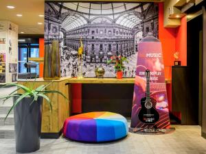 a room with a guitar and a bottle of wine at Ibis Milano Centro in Milan