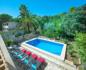 a swimming pool with chairs and a table at Owl Booking Villa Irina - 2 Min Walk To The Old Town in Pollença