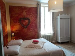een slaapkamer met een bed met een hart aan de muur bij Château d'Arfeuilles Chambres et tables d'hôtes in Arfeuilles