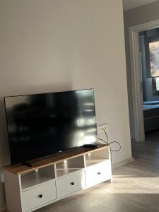 einen Flachbild-TV auf einem weißen Entertainment-Center in der Unterkunft Magnificent Flat with Shared Pool in Milas in Milas