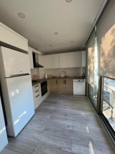 eine Küche mit weißen Schränken und einem großen Fenster in der Unterkunft Magnificent Flat with Shared Pool in Milas in Milas