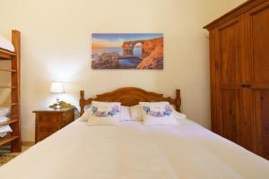 a bedroom with a large white bed with two pillows at Lantern Stay in Marsalforn