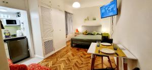 Habitación con cama, mesa y TV. en Bookingrent Palermo1 en Buenos Aires