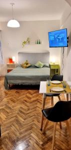 1 dormitorio con cama, mesa y TV en Bookingrent Palermo1 en Buenos Aires