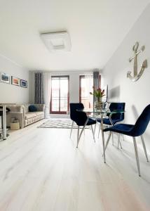 a white living room with a table and chairs at See U in Szczecin in Szczecin