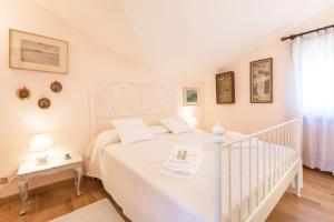 Un dormitorio blanco con una cama blanca y una escalera en Maison Jaune by Wonderful Italy en Bellagio