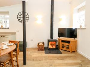 un soggiorno con stufa a legna e TV di Wensum Spring a Whissonsett