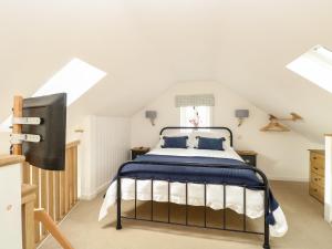 a bedroom with a bed in a attic at Wensum Spring in Whissonsett