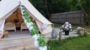 Hopgarden Glamping Exclusive site hire - Sleep up to 50 guests في Wadhurst: خيمة فيها بالونات وزهور في ساحة