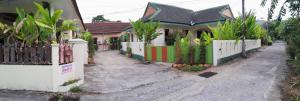 a house with a white fence in front of it at Bangtoa room with kitchen near Lotus MMA & Beach in Bang Tao Beach