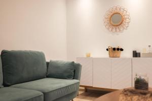 uma sala de estar com um sofá e um espelho em IMMOGROOM - 10 min from the city center - Renovated - Nice and cosy em Cannes
