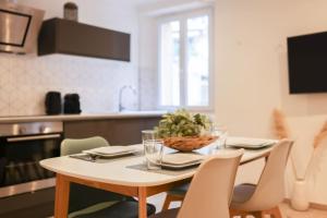 een keuken met een tafel met stoelen en een tafel bij IMMOGROOM - 10 min from the city center - Renovated - Nice and cosy in Cannes