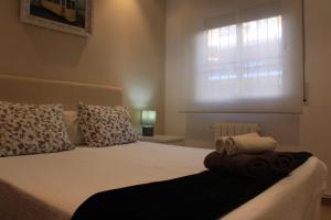 - une chambre avec un lit doté d'oreillers et d'une fenêtre dans l'établissement Can Robert Apartment by SitgesNow, à Sitges