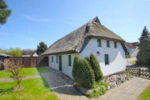 an old cottage with a thatched roof at wassernahes Haus mit Terrasse und Garten - Ferienhaus Storchennest Haus rechte Seite in Wiek auf Rügen 