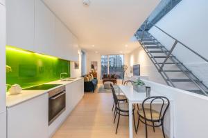 a kitchen and dining room with a green accent wall at A Starry Starry Night - Borough - by Frankie Says in London