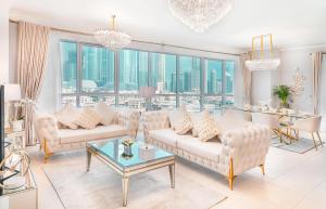 a living room with white furniture and a large window at Elite Royal Apartment - Full Burj Khalifa and Fountain View - The Royal in Dubai