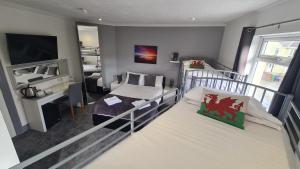 a bedroom with two bunk beds and a television at Y Gwynedd Inn in Llanberis