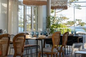a dining room with a table and chairs and windows at finca dos Mares in Ferrol