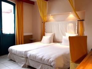 Postel nebo postele na pokoji v ubytování Logis Hôtel Les Pages