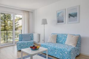 a living room with a couch and a chair at Wellness & SPA Resort Aquamarine Apartment by Renters in Dziwnów