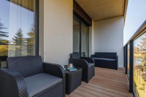 a balcony with wicker chairs and a table at Wellness & SPA Resort Aquamarine Apartment by Renters in Dziwnów
