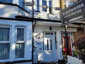 un edificio azul con una puerta blanca y un cartel de no vacantes en Edelweiss Guest House, en Southend-on-Sea