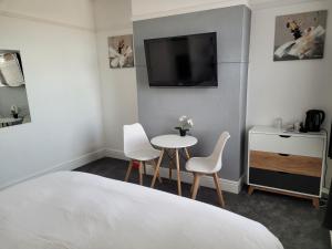 - une chambre avec une table, 2 chaises et une télévision dans l'établissement Edelweiss Guest House, à Southend-on-Sea