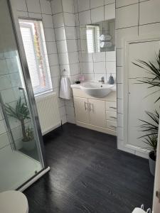 een badkamer met een wastafel en een spiegel bij Edelweiss Guest House in Southend-on-Sea