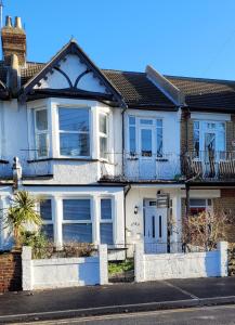 a white house with white windows and a balcony at Edelweiss Guest House in Southend-on-Sea