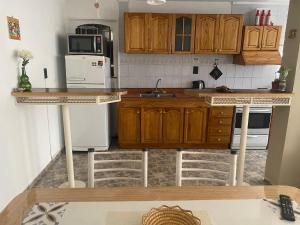 a kitchen with wooden cabinets and white appliances at Casa Olive, en complejo residencial con cochera in Godoy Cruz +5 photos