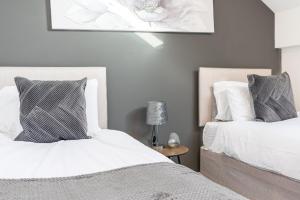 dwa łóżka siedzące obok siebie w sypialni w obiekcie Spacious 3 Bedroom Apartment w mieście Barrow in Furness