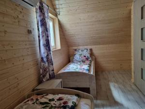 a small room with two beds and a window at Kwiatowe Domki in Rogowo