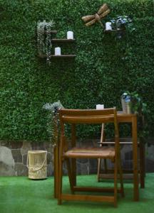 una silla y una mesa frente a una pared verde en PACOROOMS, en Madrid
