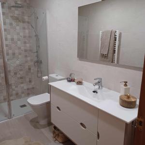 a bathroom with a sink and a toilet and a mirror at La casa del gatico in Lumbier