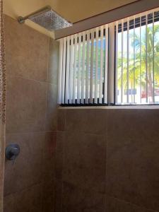 a bathroom with a shower with a window and a shower at Lujoso Departamento en Zona Dorada de Acapulco in Acapulco