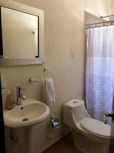 a bathroom with a sink and a toilet and a mirror at Lujoso Departamento en Zona Dorada de Acapulco in Acapulco
