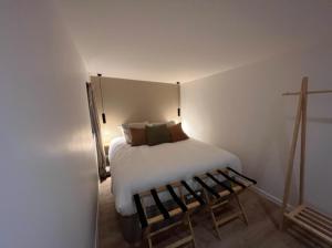 a bedroom with a white bed and a bench at Casa Melodia in Pontoise