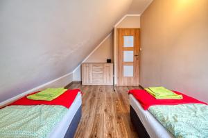 twee bedden in een kamer met een trap bij Domek na Kaszubach na Gwizdowce in Załakowo