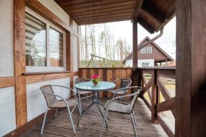 een patio met een tafel en stoelen op een veranda bij Domek na Kaszubach na Gwizdowce in Załakowo