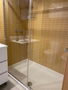 La salle de bains est pourvue d'une douche avec une porte en verre. dans l'établissement Exclusivo piso con terraza al lado de la playa, à Lloret de Mar