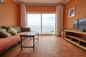 een woonkamer met een bank en een groot raam bij apartment with breathtaking view in Burgau