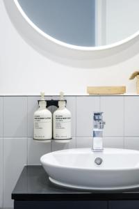 a bathroom with a sink and two bottles of soap at Studio Apartments at Aurora near Melbourne Port in Melbourne