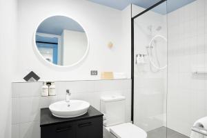 La salle de bains est pourvue d'un lavabo, de toilettes et d'un miroir. dans l'établissement Studio Apartments at Aurora near Melbourne Port, à Melbourne