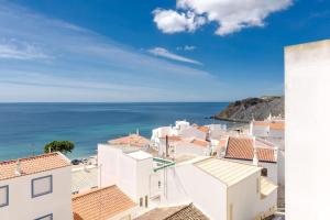 uitzicht op een stad met witte gebouwen en de oceaan bij apartment with breathtaking view in Burgau